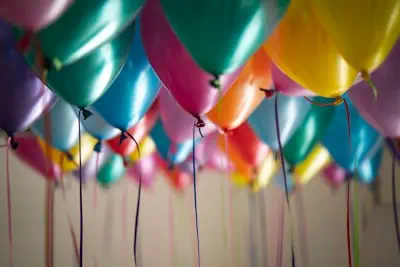 Helium balloons floating against a ceiling at a house party in New York