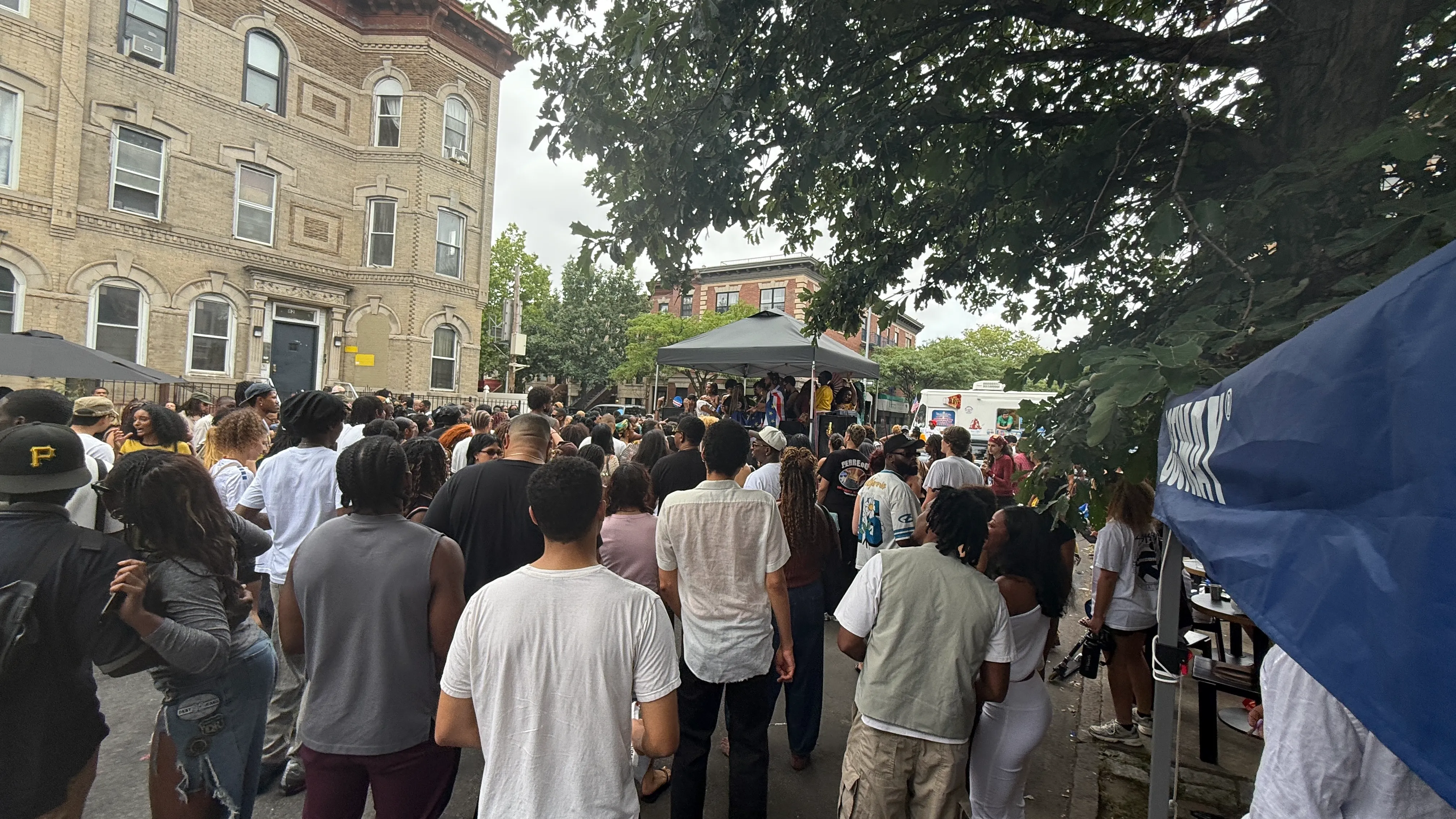 Party rentals near me in action - a portable stage under a pop-up tent at a Bushwick block party, Brooklyn