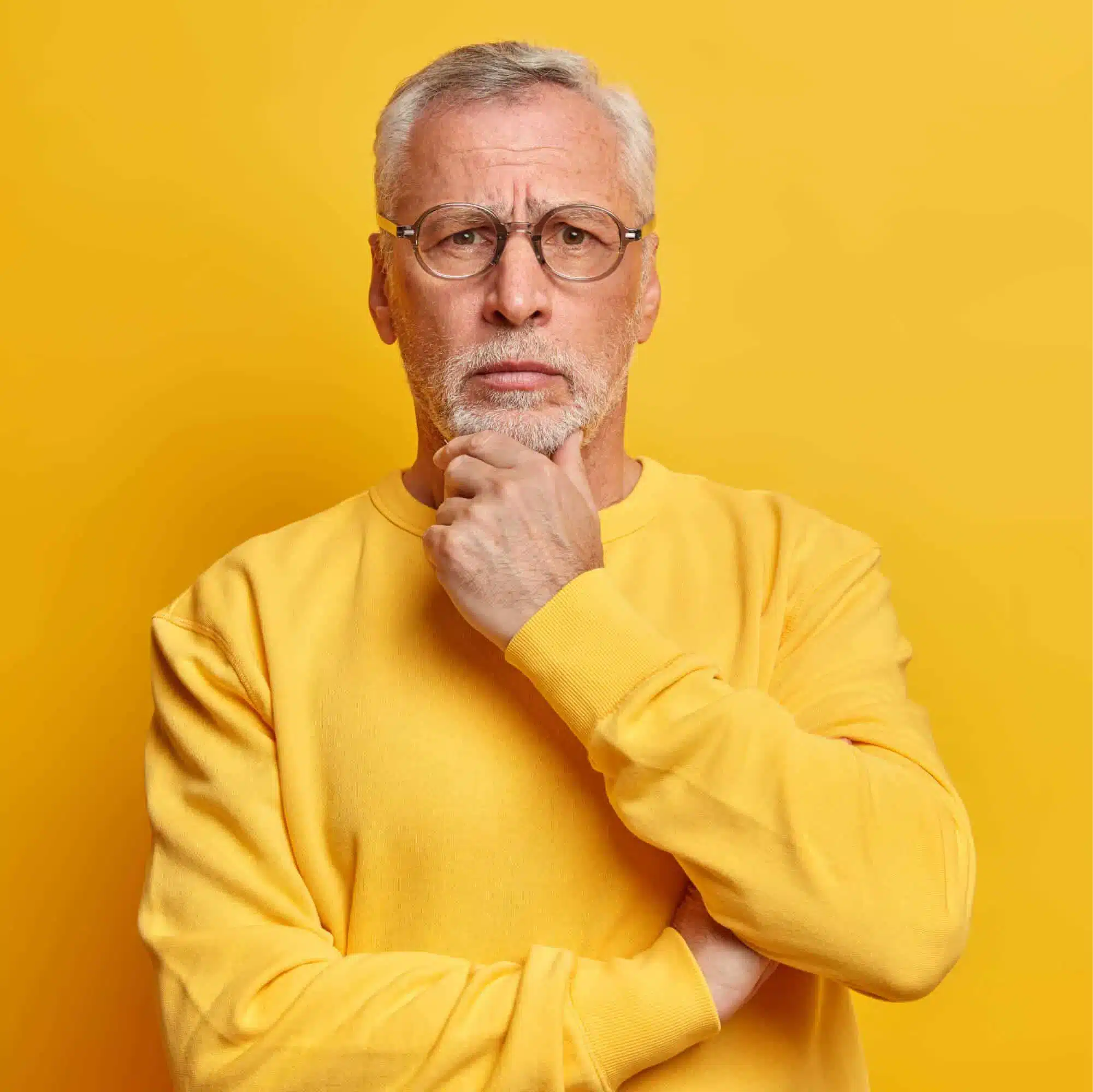 a man with a beard wearing a yellow shirt